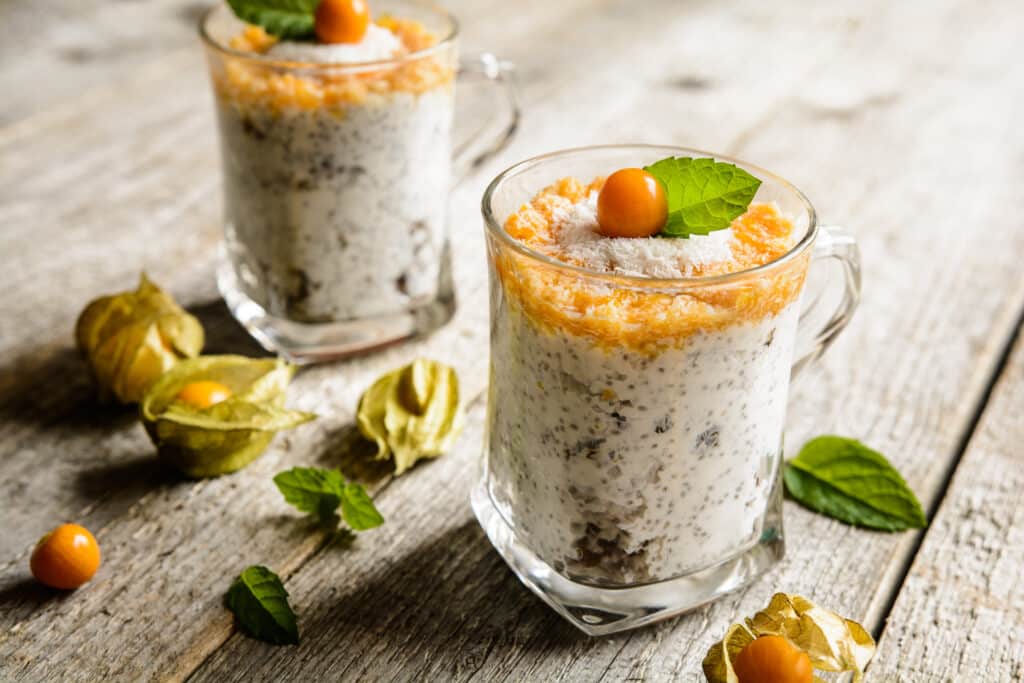 Probiotic yogurt with chia seeds, coconut, honey and physalis puree in a glass jar
