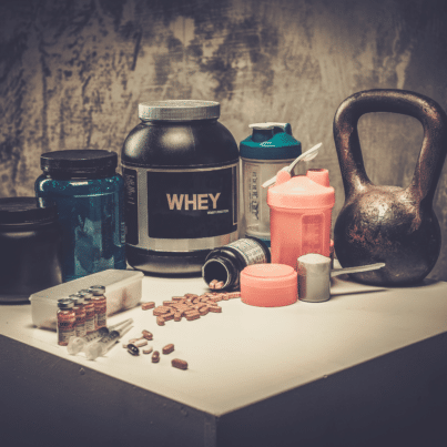 supplement containers on counter with kettlebell